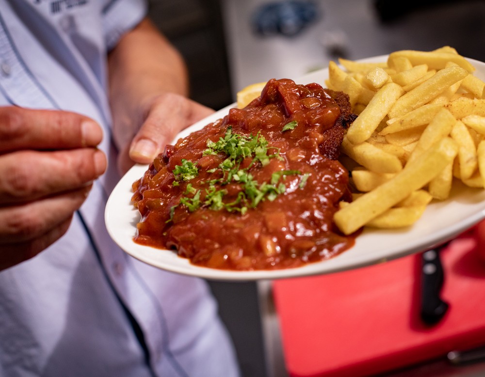 Ein Schnitzel mit Pommes auf einem Teller dekoriert.