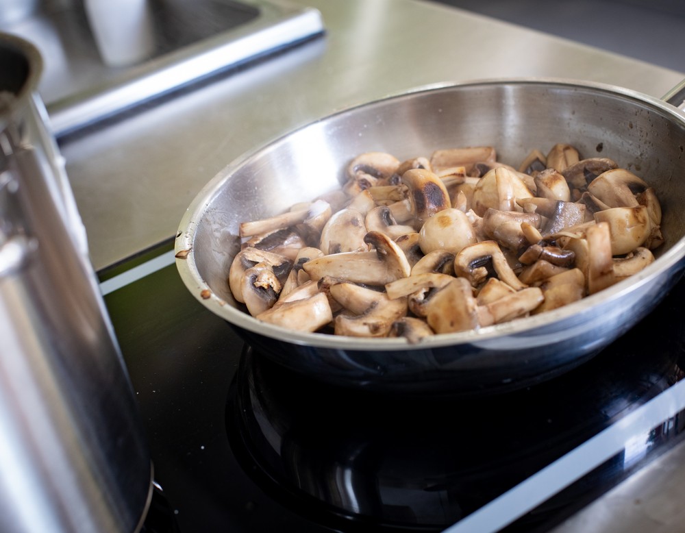 Frische Champignons, die in der Pfanne angebraten werden.